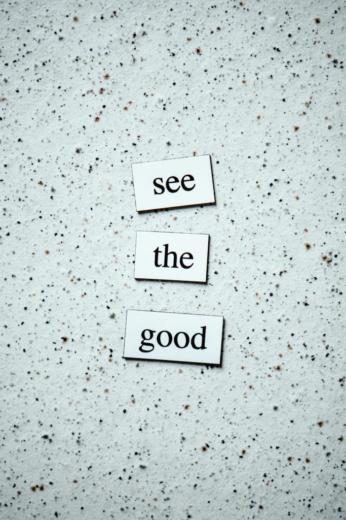 Inspiring words 'See the Good' displayed on a speckled backdrop.